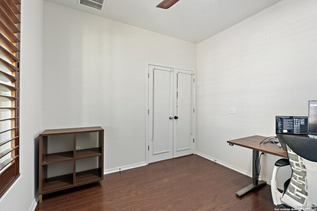 office with baseboards, visible vents, wood finished floors, and a ceiling fan