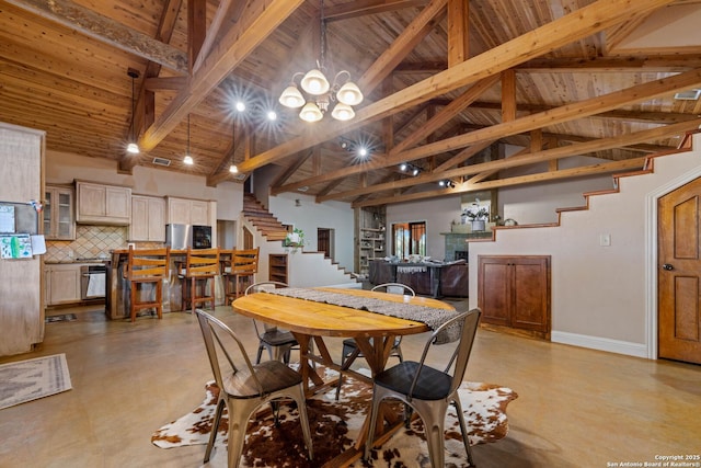 dining area featuring beam ceiling, a notable chandelier, finished concrete flooring, stairway, and high vaulted ceiling