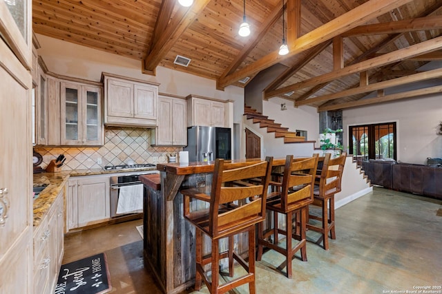 kitchen featuring decorative backsplash, stainless steel appliances, visible vents, and concrete floors