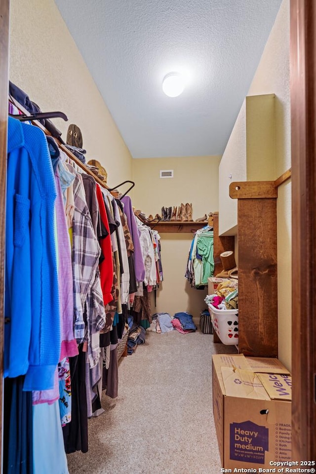 walk in closet with visible vents and carpet flooring