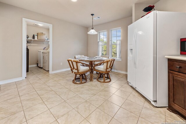 dining area featuring baseboards, visible vents, washing machine and clothes dryer, and light tile patterned floors
