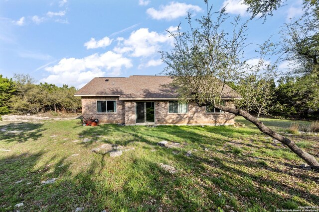 rear view of house featuring a lawn