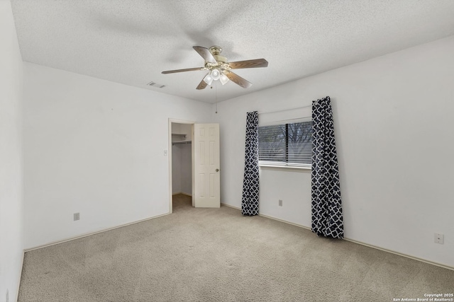 2343 Country Grace, New Braunfels, TX 78130 - unfurnished bedroom with a spacious closet, carpet, a textured ceiling, ceiling fan, and visible vents
