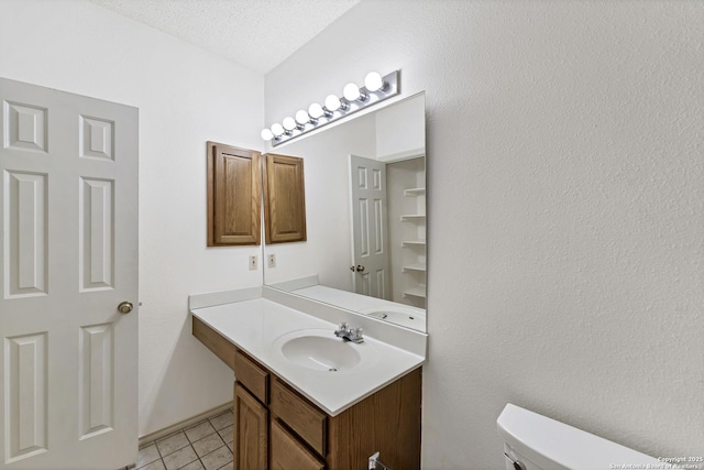 2343 Country Grace, New Braunfels, TX 78130 - half bathroom with a textured ceiling, toilet, tile patterned floors, and vanity