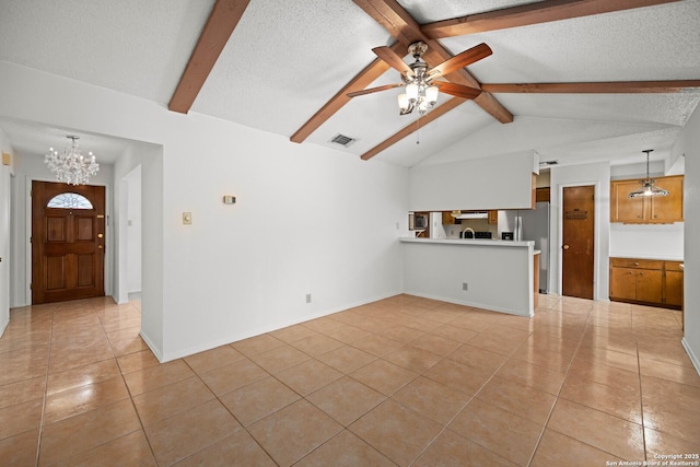 unfurnished living room featuring a textured ceiling, ceiling fan with notable chandelier, light tile patterned floors, and visible vents