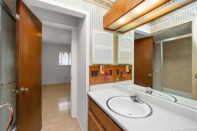 full bath with a shower with shower door, tile patterned flooring, and vanity