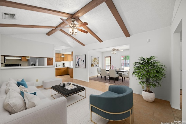 living room with a textured ceiling, light tile patterned flooring, lofted ceiling with beams, and a ceiling fan
