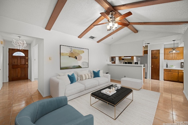 living room with ceiling fan with notable chandelier, a textured ceiling, visible vents, light tile patterned flooring, and vaulted ceiling with beams