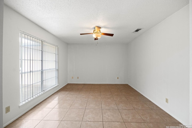 unfurnished room featuring a healthy amount of sunlight, ceiling fan, and light tile patterned floors