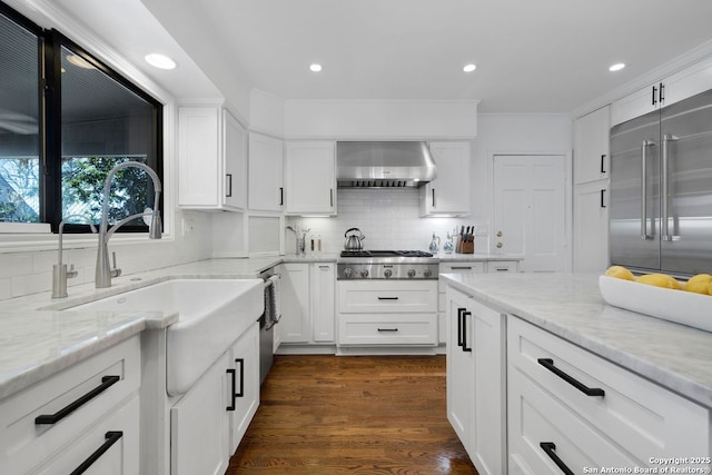 112 Coventry Ln, Terrell Hills, TX 78209 - kitchen with white cabinetry, stainless steel appliances, dark wood-type flooring, and wall chimney exhaust hood