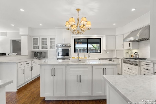 112 Coventry Ln, Terrell Hills, TX 78209 - kitchen with white cabinets, stainless steel gas cooktop, a center island with sink, a sink, and wall chimney range hood