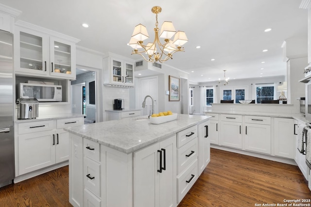 112 Coventry Ln, Terrell Hills, TX 78209 - kitchen featuring dark wood finished floors, a center island with sink, a sink, a notable chandelier, and white microwave