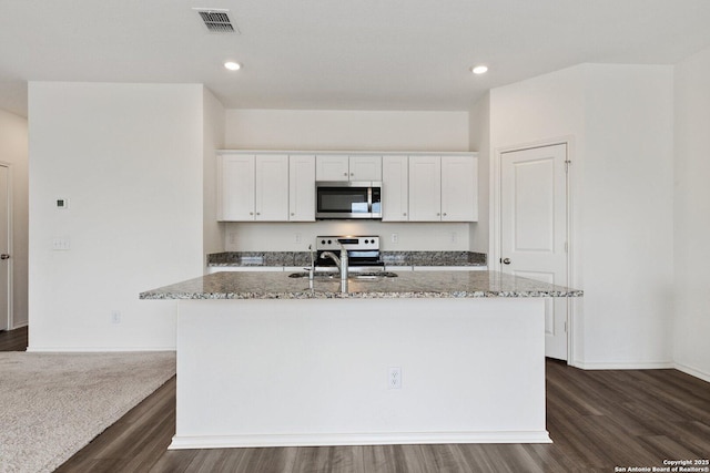 kitchen with a sink, visible vents, light stone counters, and appliances with stainless steel finishes