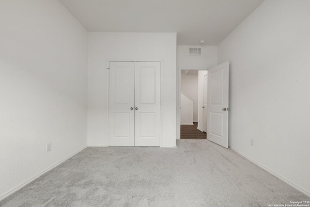 unfurnished bedroom featuring visible vents, a closet, and carpet floors