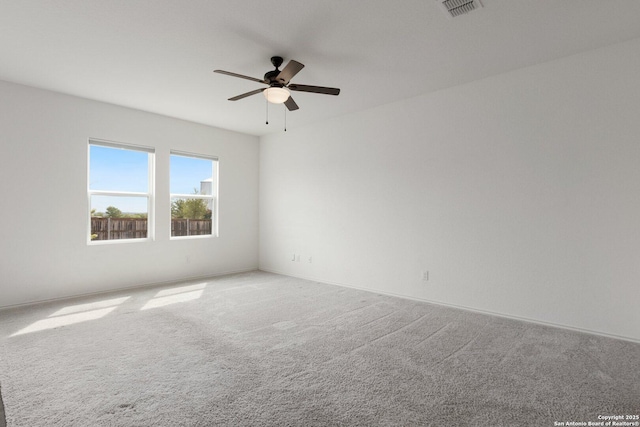 carpeted spare room with visible vents and ceiling fan