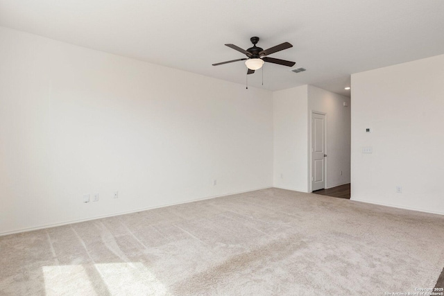 carpeted empty room with visible vents and a ceiling fan