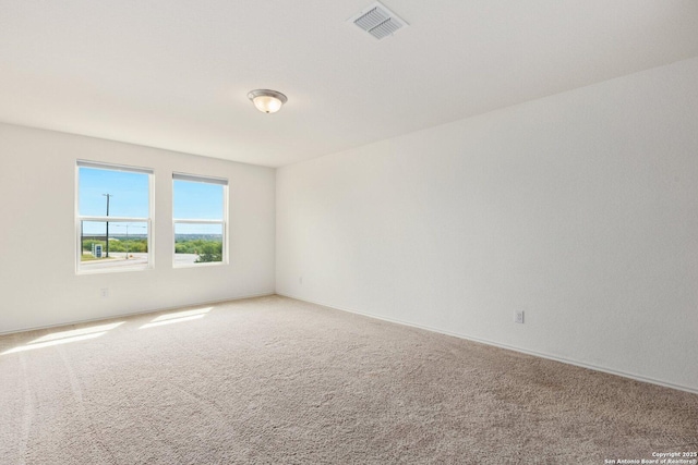 empty room featuring visible vents and light carpet