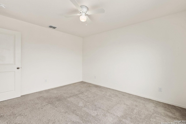 carpeted spare room featuring a ceiling fan and visible vents