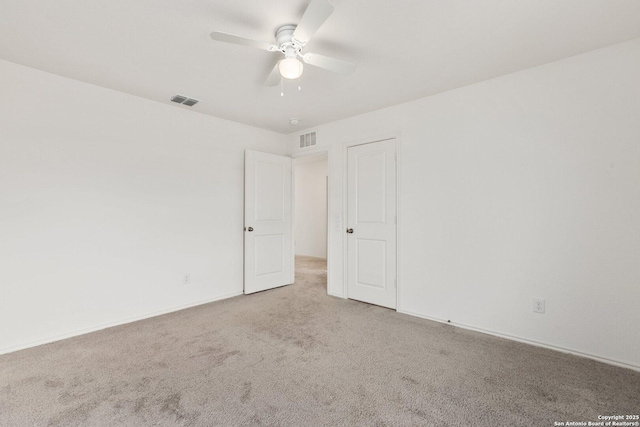 empty room with a ceiling fan, carpet floors, and visible vents