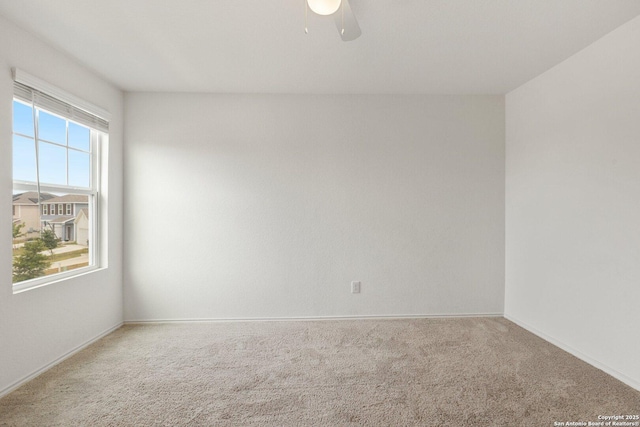 spare room featuring baseboards, carpet floors, and a ceiling fan
