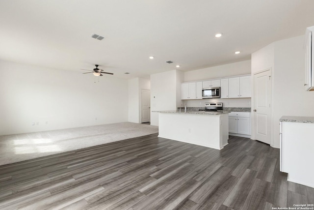 kitchen featuring visible vents, stainless steel appliances, a ceiling fan, white cabinetry, and open floor plan