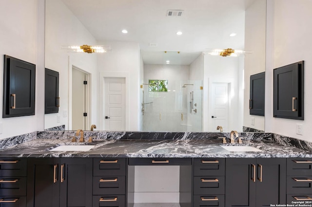 bathroom featuring visible vents, a shower stall, double vanity, and a sink