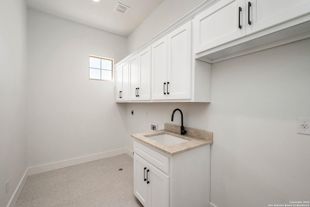 laundry area with hookup for an electric dryer, baseboards, cabinet space, and a sink