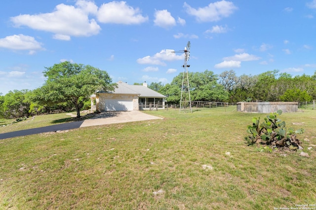 view of yard featuring driveway, fence, and an attached garage