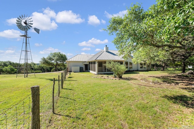 view of yard featuring fence and a sunroom
