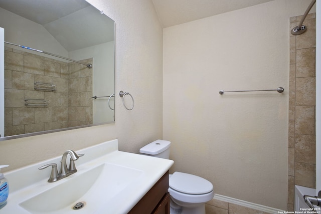 bathroom featuring tile patterned flooring, vanity, toilet, lofted ceiling, and a shower