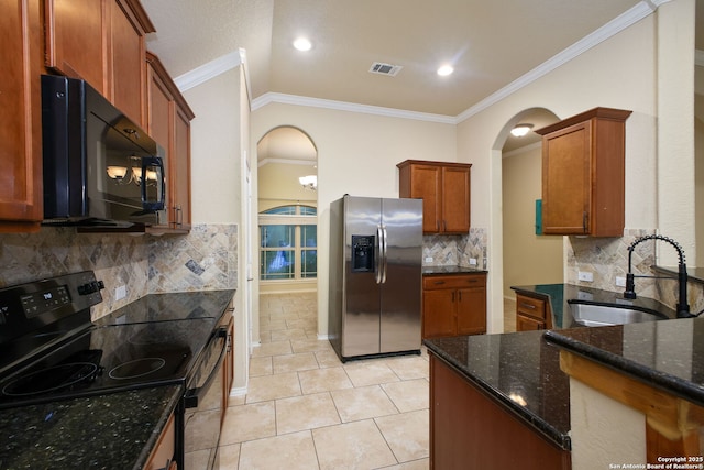 kitchen featuring visible vents, crown molding, arched walkways, a sink, and black appliances