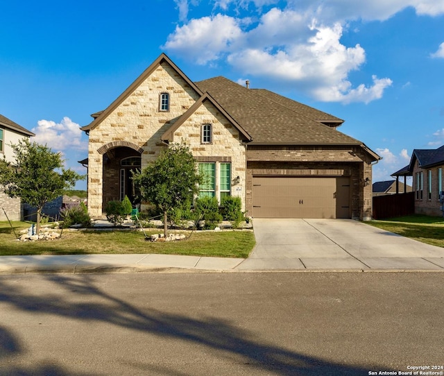 view of front of house with a garage, concrete driveway, brick siding, a front lawn, and a shingled roof