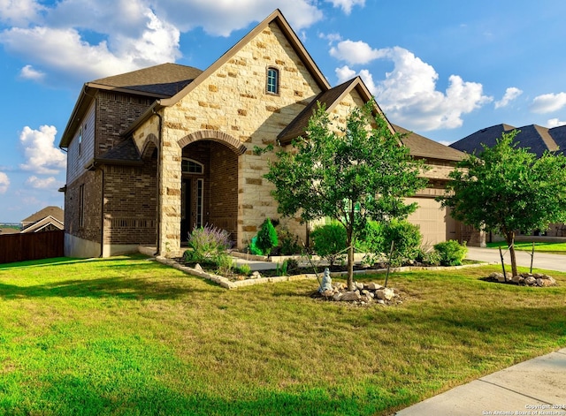 view of front of house featuring concrete driveway, an attached garage, stone siding, a front yard, and brick siding