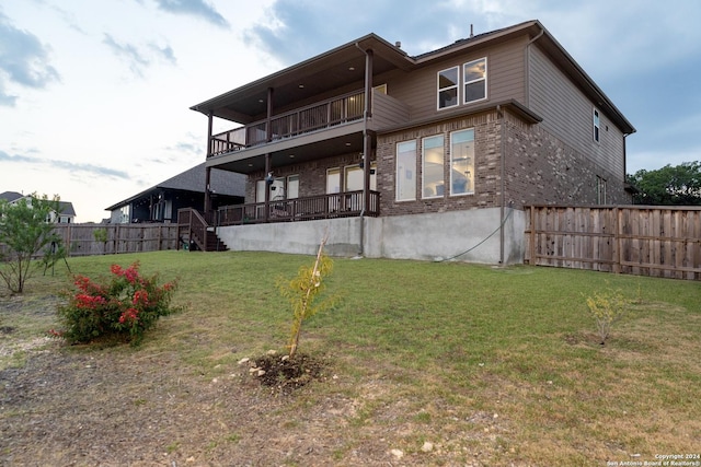 back of house featuring a yard, brick siding, and fence