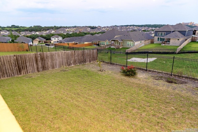 view of yard featuring a fenced backyard and a residential view
