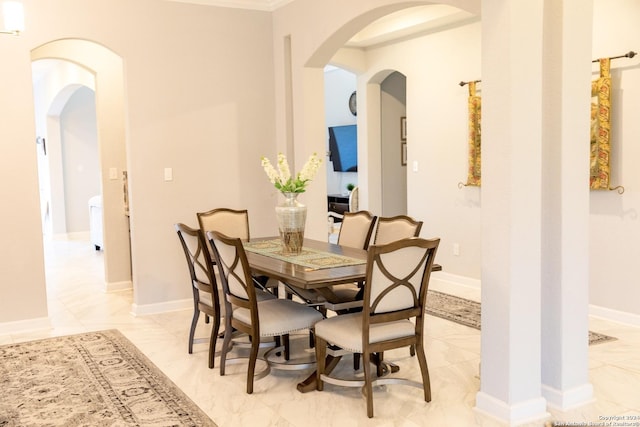 dining area featuring baseboards and arched walkways