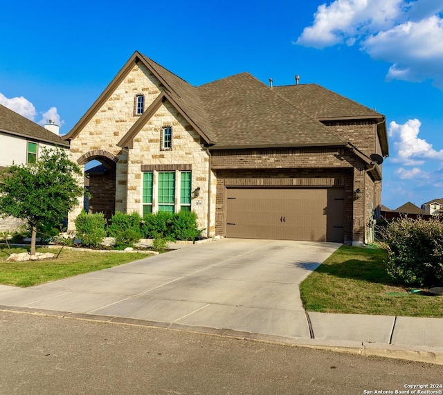 view of front of house with brick siding, concrete driveway, a garage, and a shingled roof
