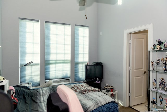 bedroom featuring light carpet, multiple windows, and ceiling fan