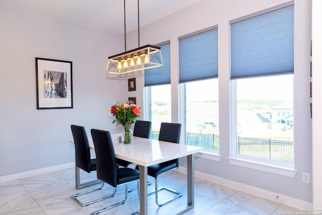 dining room featuring baseboards and an inviting chandelier