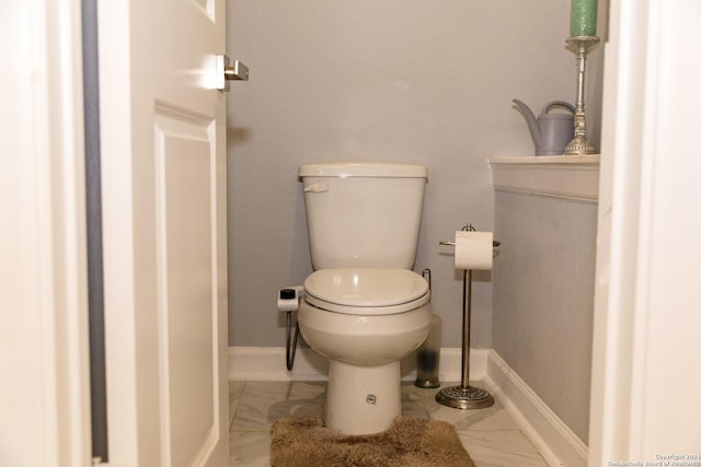 bathroom with baseboards, marble finish floor, and toilet