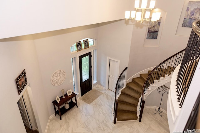 entrance foyer with a healthy amount of sunlight, stairway, and a notable chandelier