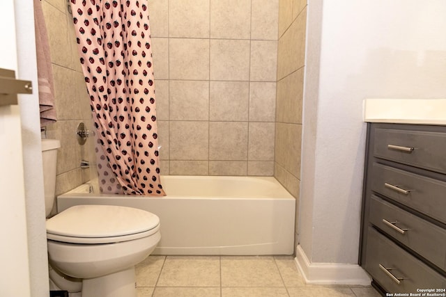 bathroom featuring tile patterned flooring, vanity, shower / tub combo with curtain, toilet, and baseboards