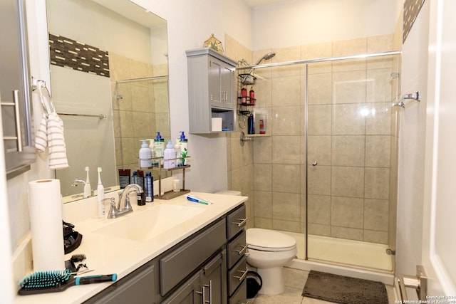 bathroom with toilet, vanity, tile patterned floors, and a shower stall
