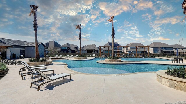 community pool with a residential view, fence, and a patio area