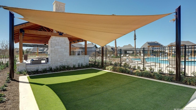 view of yard featuring a community pool, fence, and a patio area