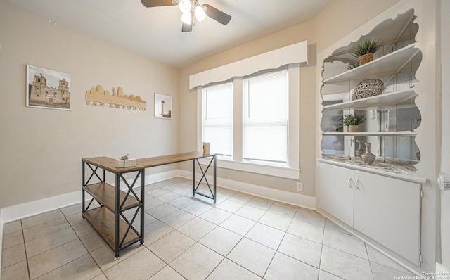 office space with baseboards, ceiling fan, and light tile patterned floors