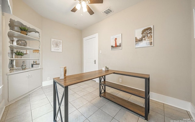 office space with light tile patterned floors, baseboards, ceiling fan, and visible vents