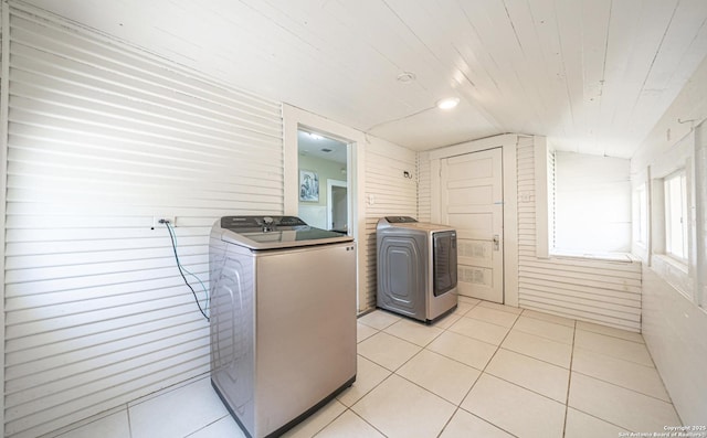 washroom with washer and clothes dryer, wooden ceiling, laundry area, and light tile patterned floors