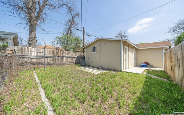 view of yard with central air condition unit and a fenced backyard