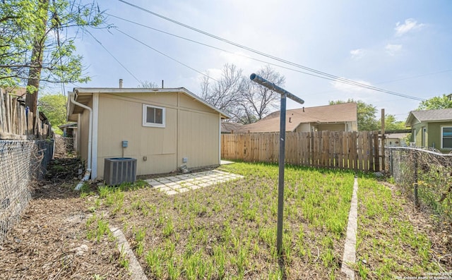 view of yard with central air condition unit and a fenced backyard